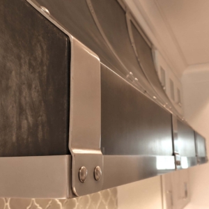 Custom Stainless Steel Basket Weave Strapping on Dark Aged Aluminum Range Hood