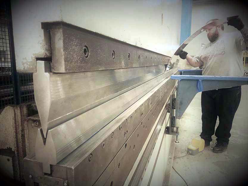 Using our 220 ton CNC press brake, Metal Artist Sparks bends his last piece for a custom copper range hood.